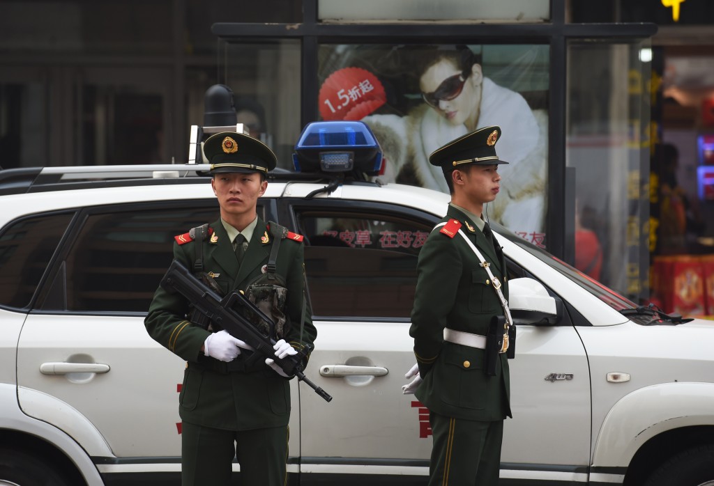 Chinese paramilitary police officers watch over pedestrians in the Wangfujing shopping district in Beijing on October 24, 2014. China's Communist rulers declared that the country would embrace the "rule of law with Chinese characteristics," official media reported after a key party meeting touted as heralding legal reform. AFP PHOTO/Greg BAKER (Photo credit should read GREG BAKER/AFP/Getty Images)