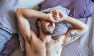 Homme tatoué souriant en se réveillant