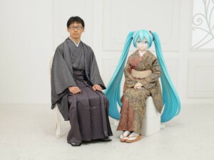 Un homme assis à côté d'un personnage fictif