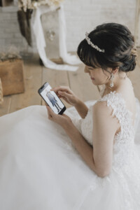 Femme en costume de mariage regardant son téléphone