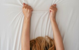 Bras de femme tirant le drap d'un lit