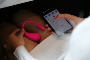 Femme tenant son smartphone ainsi que son sextoy en douce
