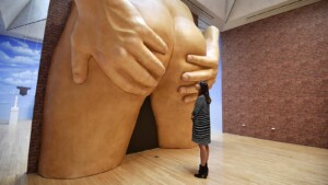Femme observant une sculpture d'un anus géant